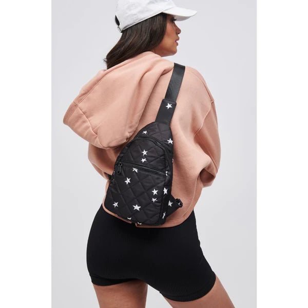 model wearing a black sling backpack with stars
