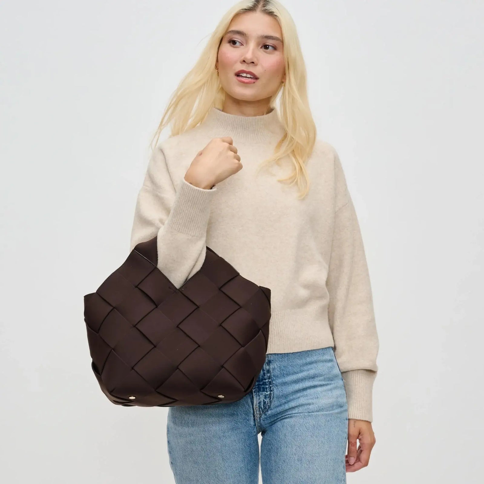 woman holding a brown bag, one of the best winter handbag colors