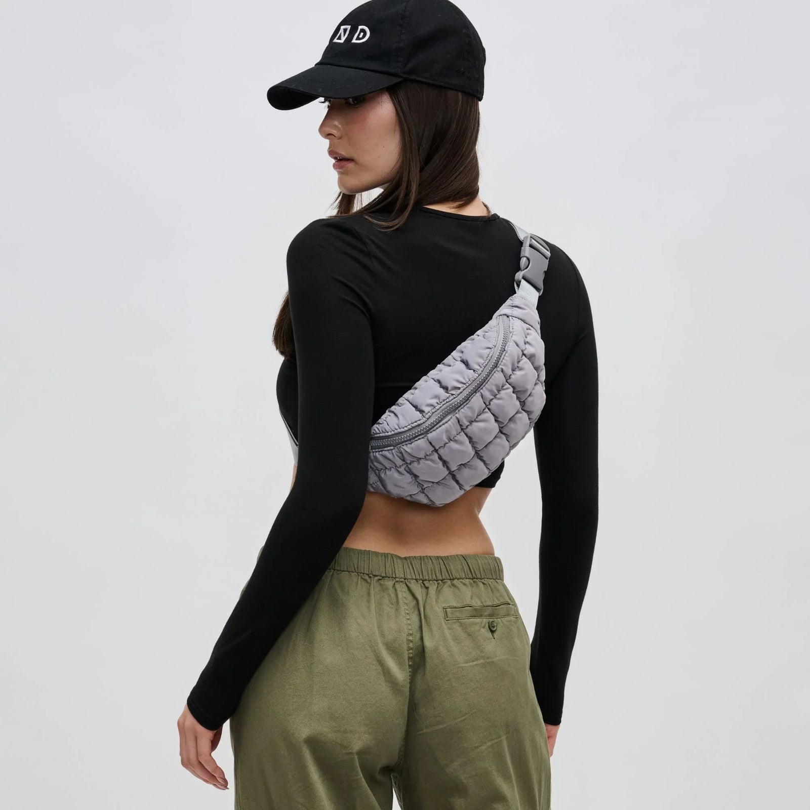 model wearing a grey belt bag across her back