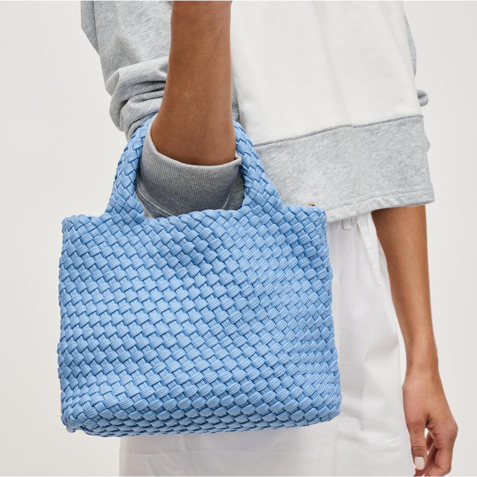 woman carrying a light blue crossbody bag on her arm