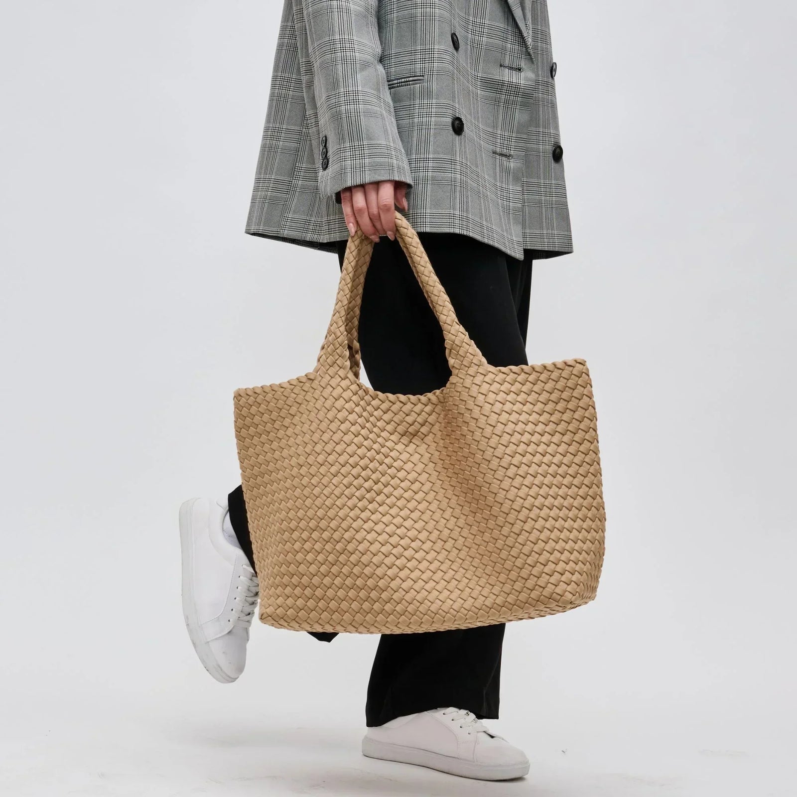 woman carrying a nude woven tote bag