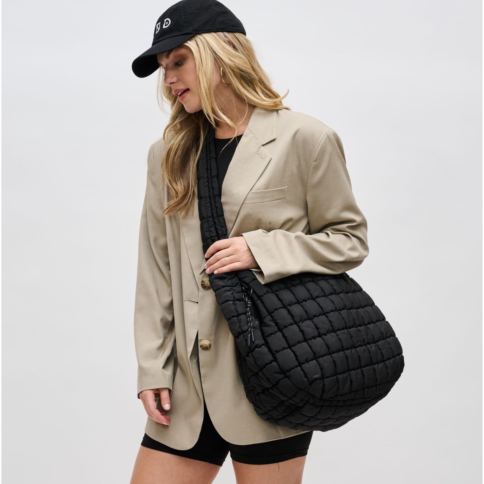 woman holding a black quilted bag
