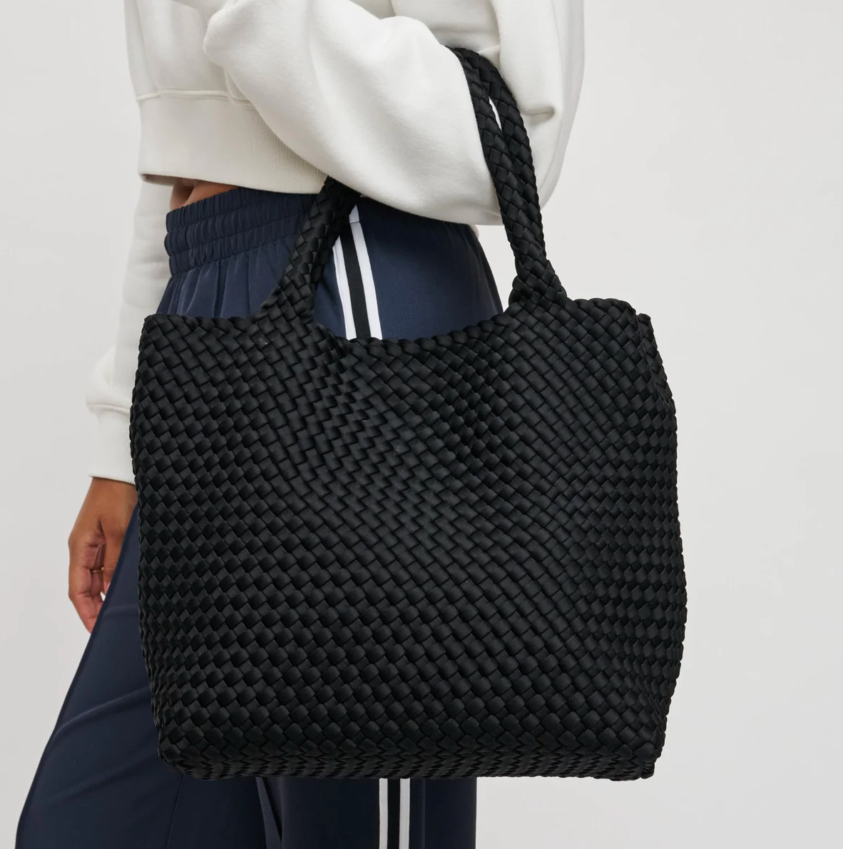 model carrying a black tote bag