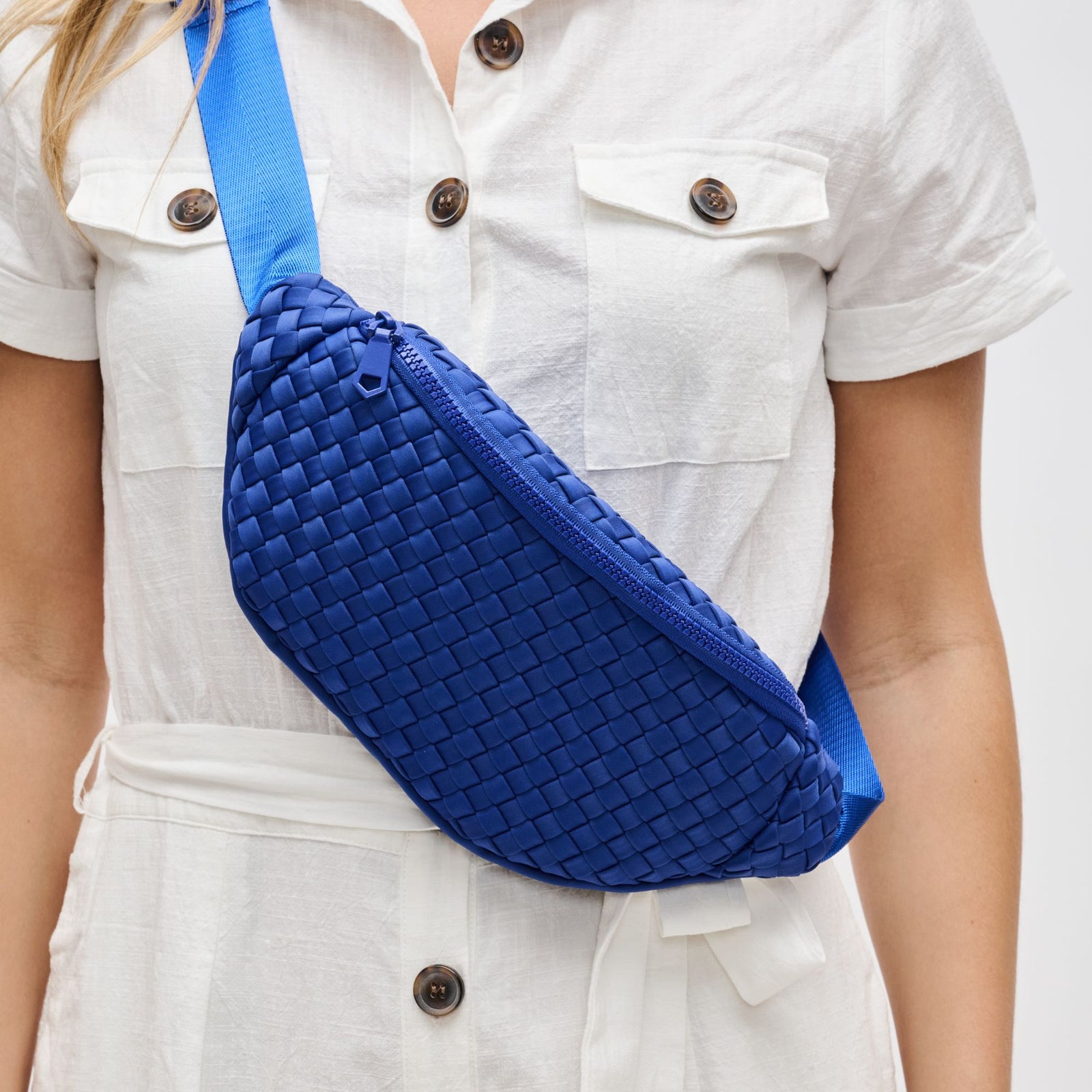 woman wearing a blue belt bag across her body