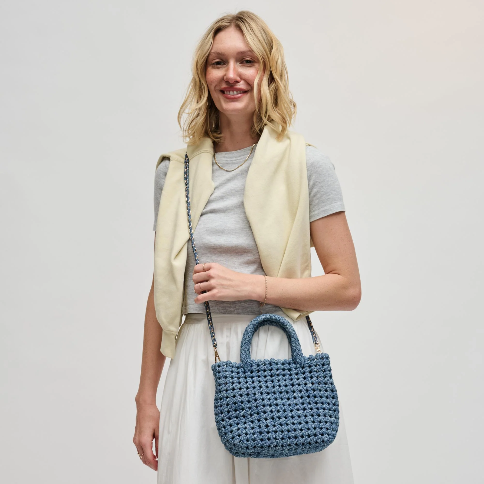 Woman carrying a blue braided crossbody purse