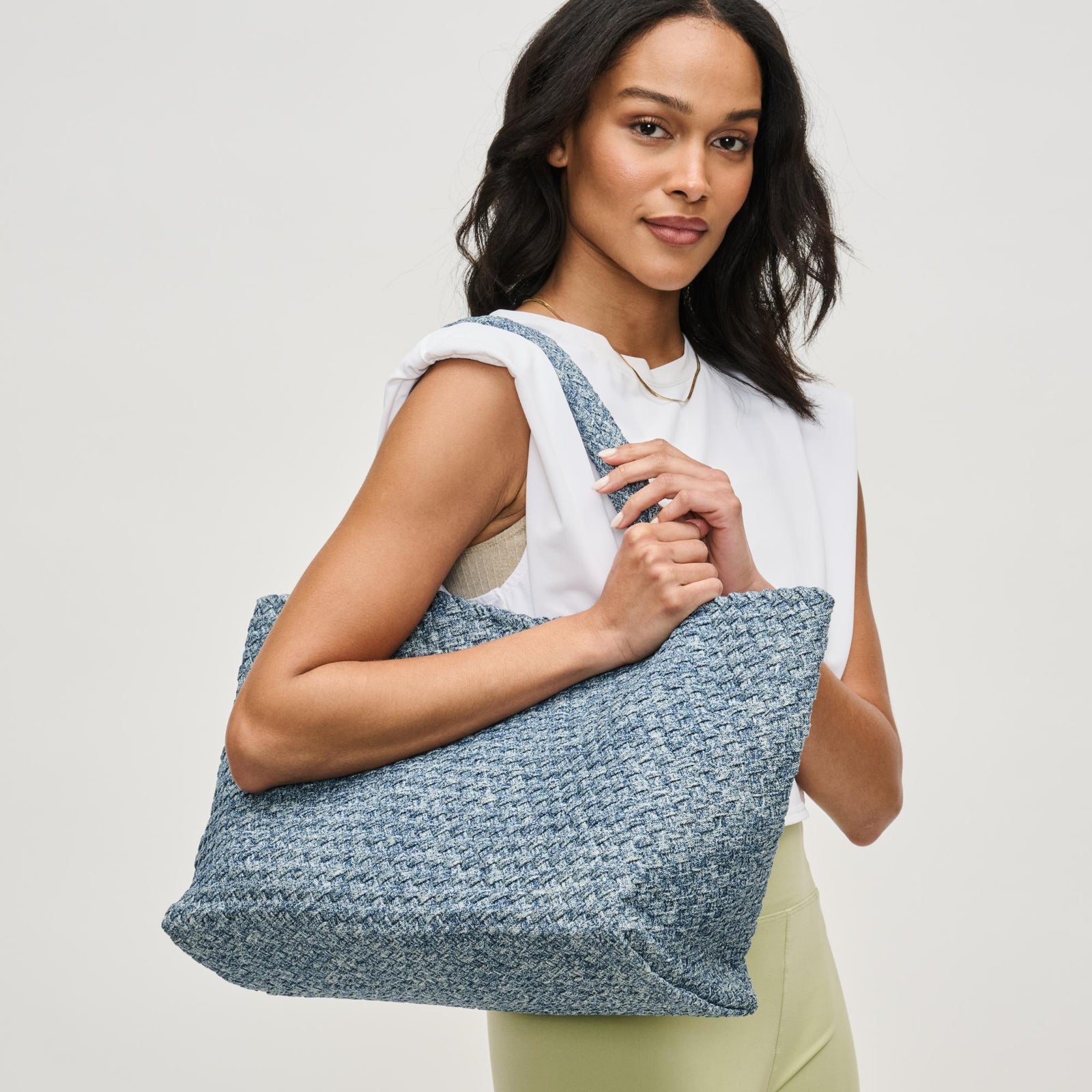 woman wearing a blue denim tote bag