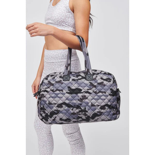 model carrying a camo duffel bag