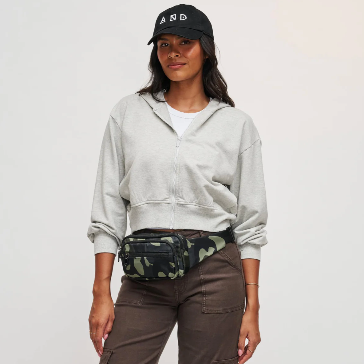 model wearing a camo print belt bag