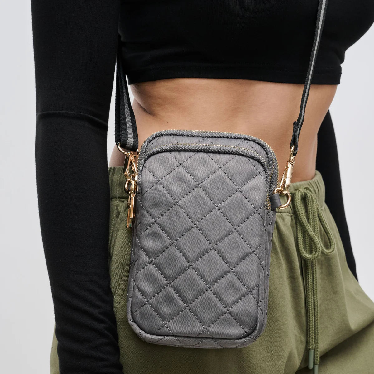 woman wearing a carbon-colored quilted crossbody bag