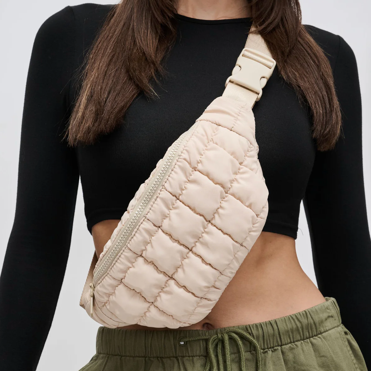 model wearing a cream belt bag across her body