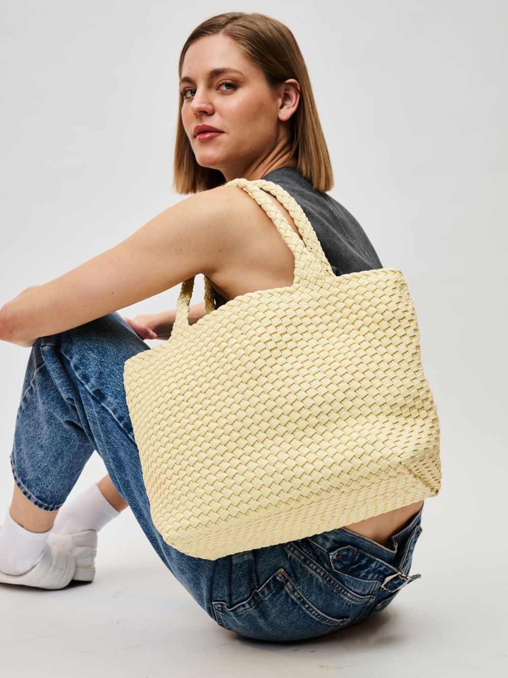 woman wearing a cream colored tote bag