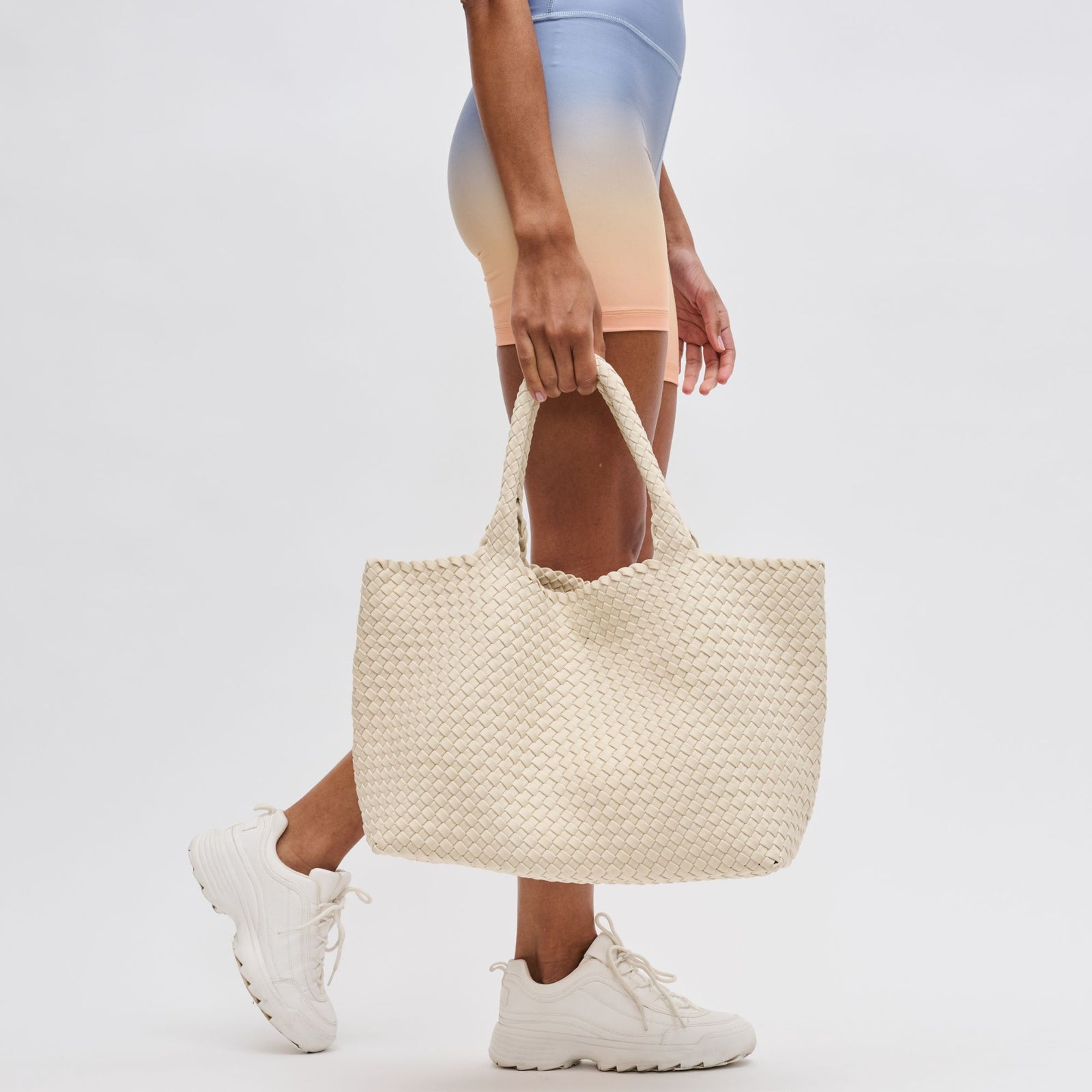 woman holding a cream neoprene tote bag