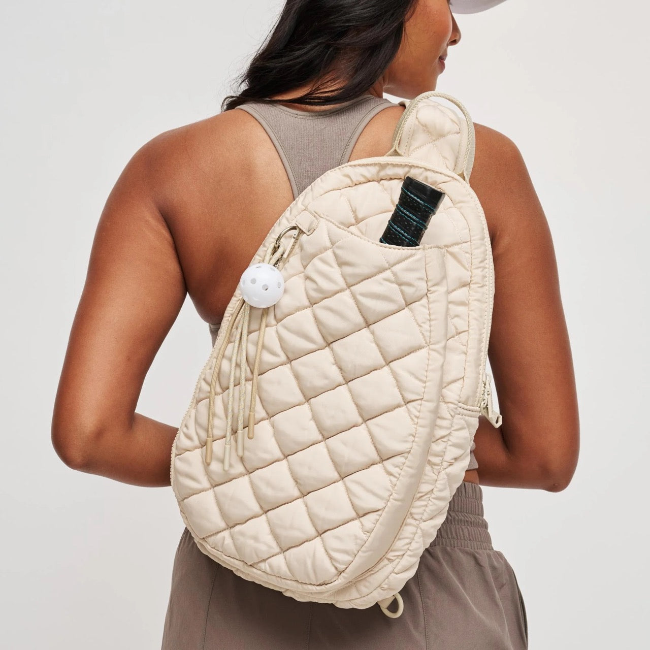 Woman wearing a cream pickleball backpack