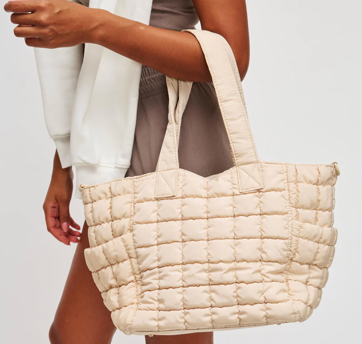 woman carrying a cream tote bag