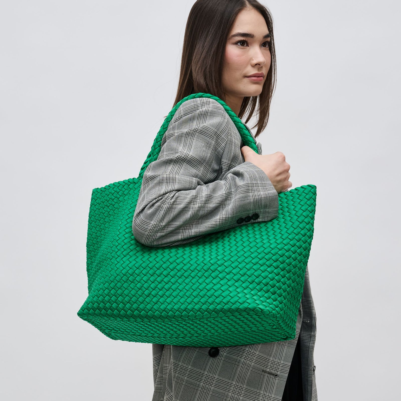 woman holding a green woven bag