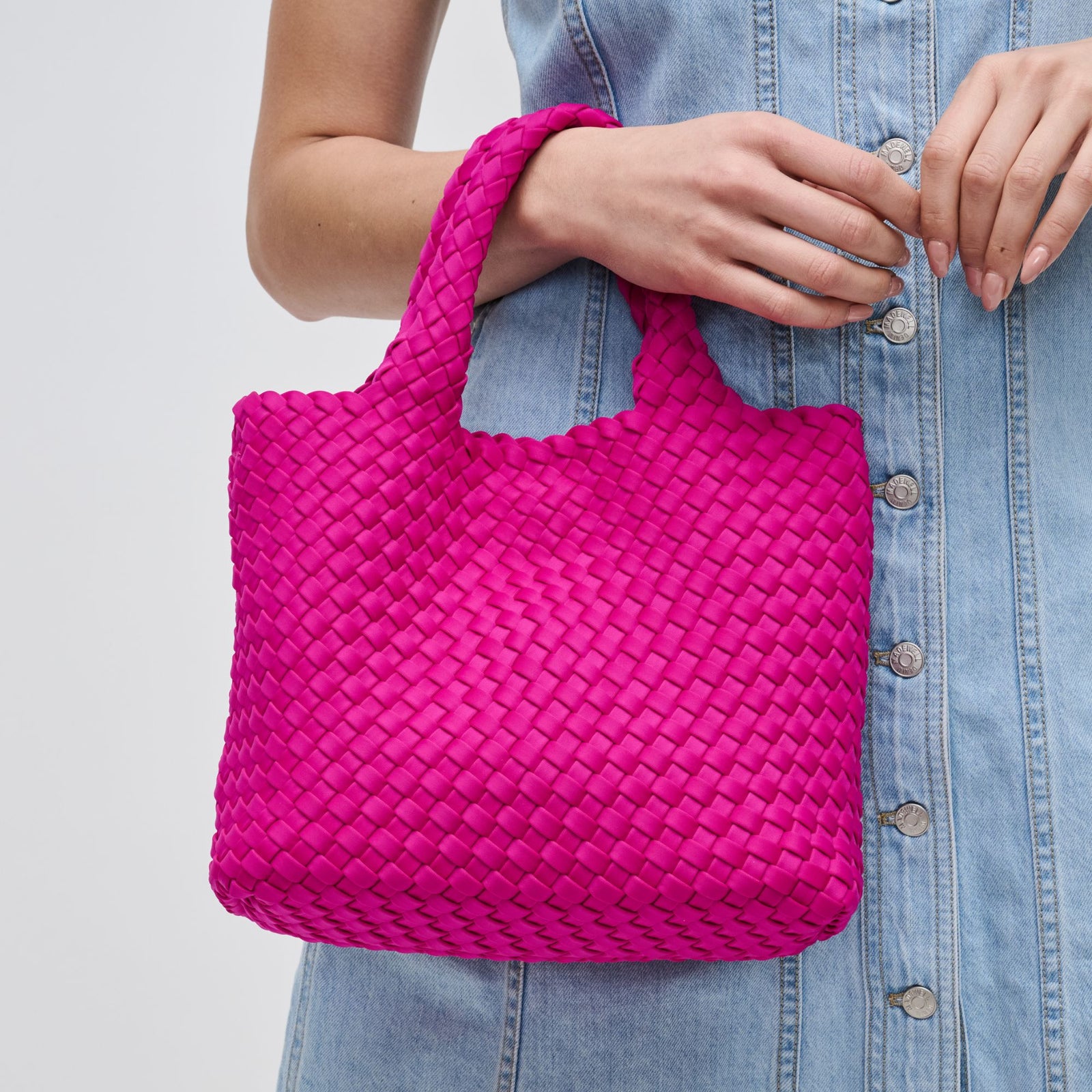 woman carrying a hot pink small tote
