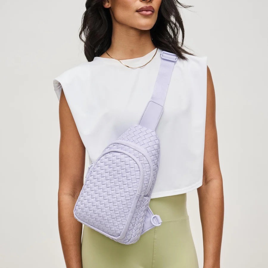 Woman wearing a light purple sling backpack