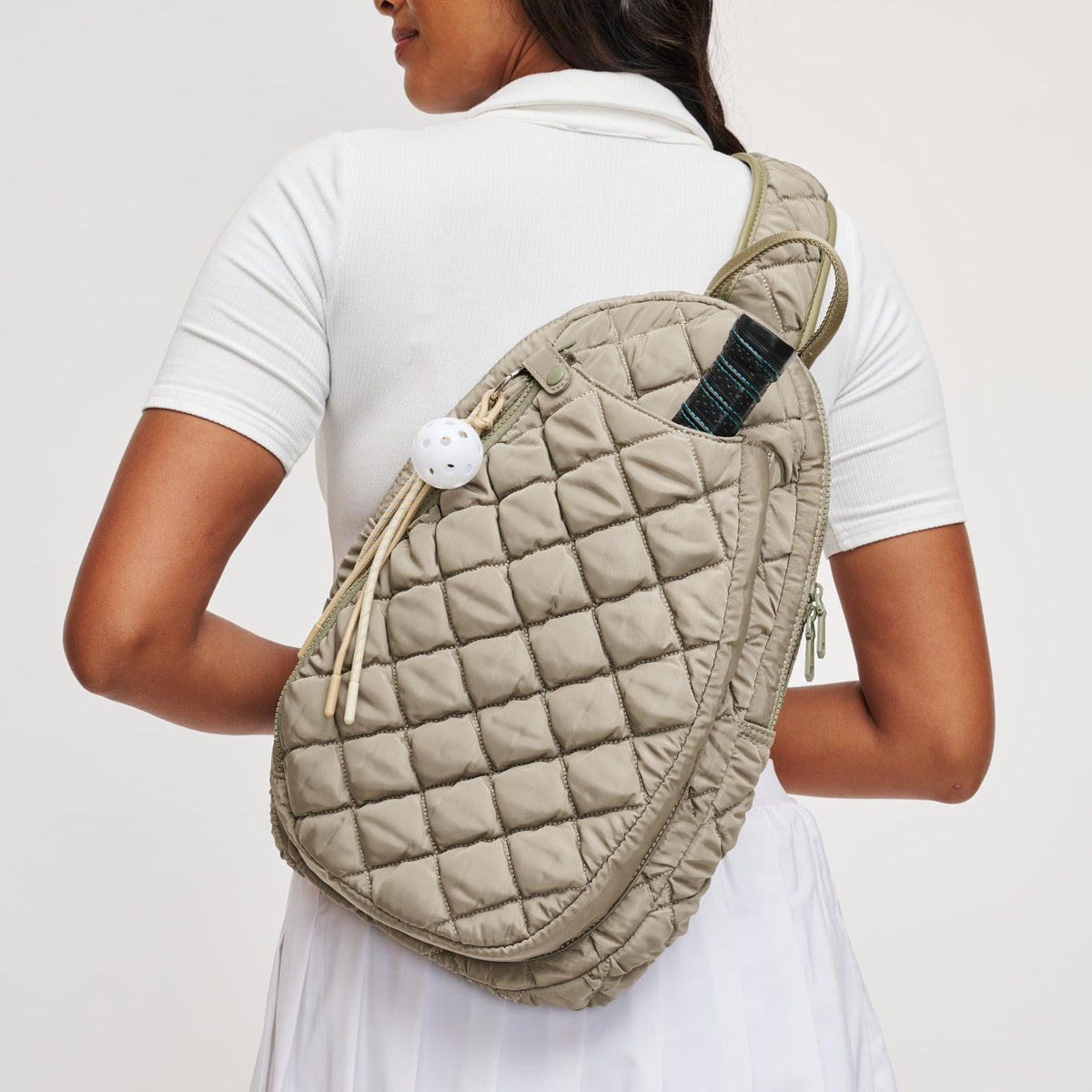 Woman wearing Desert Sage Sol and Selene Match Point - Quilted Puffer Pickleball & Paddle Tennis Sling Backpack 841764112000 View 1 | Desert Sage