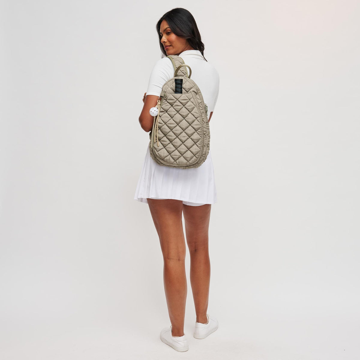 Woman wearing Desert Sage Sol and Selene Match Point - Quilted Puffer Pickleball & Paddle Tennis Sling Backpack 841764112000 View 3 | Desert Sage