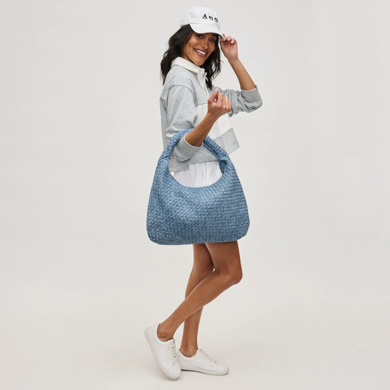 a model carrying a denim look woven tote bag