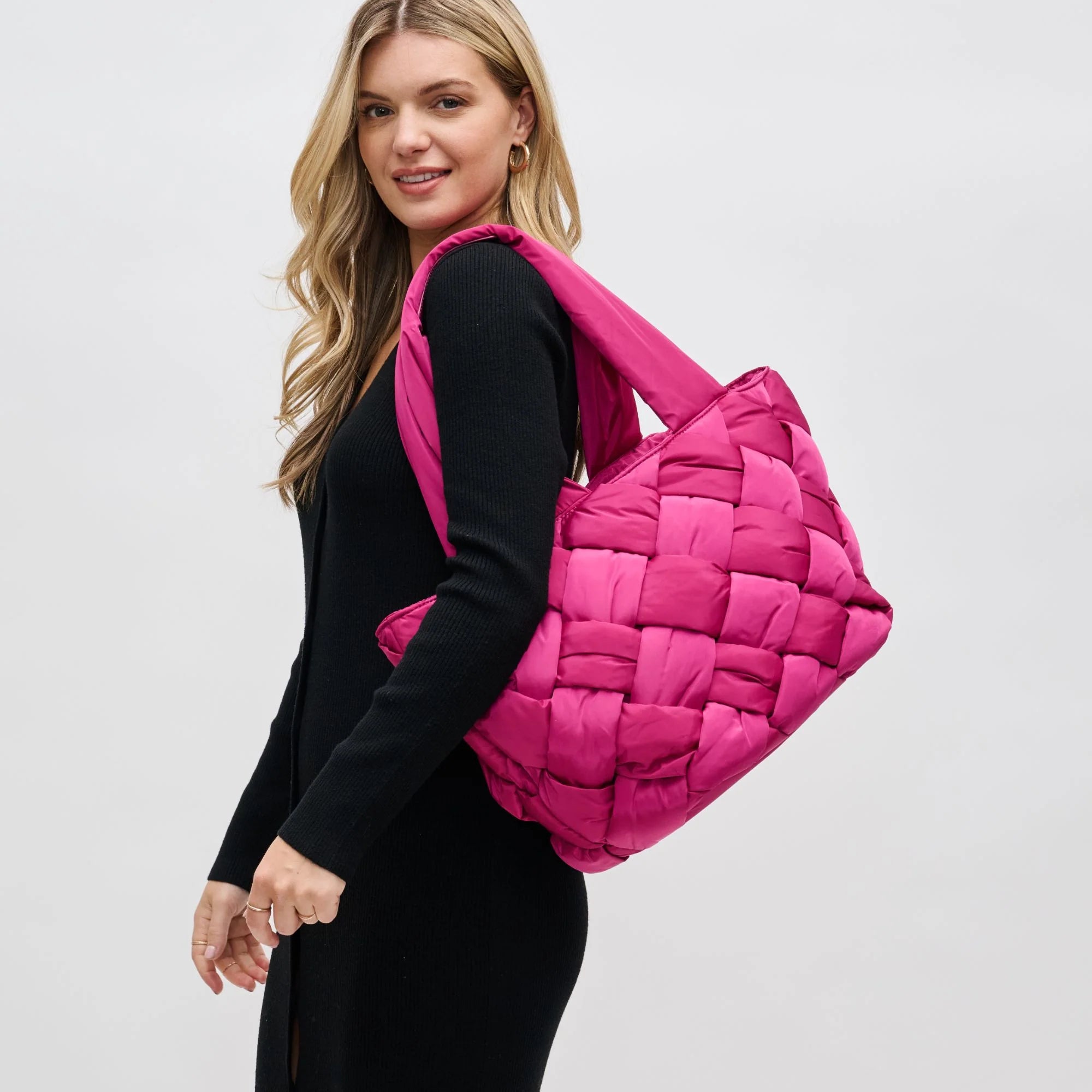 model carrying a pink puffy woven tote