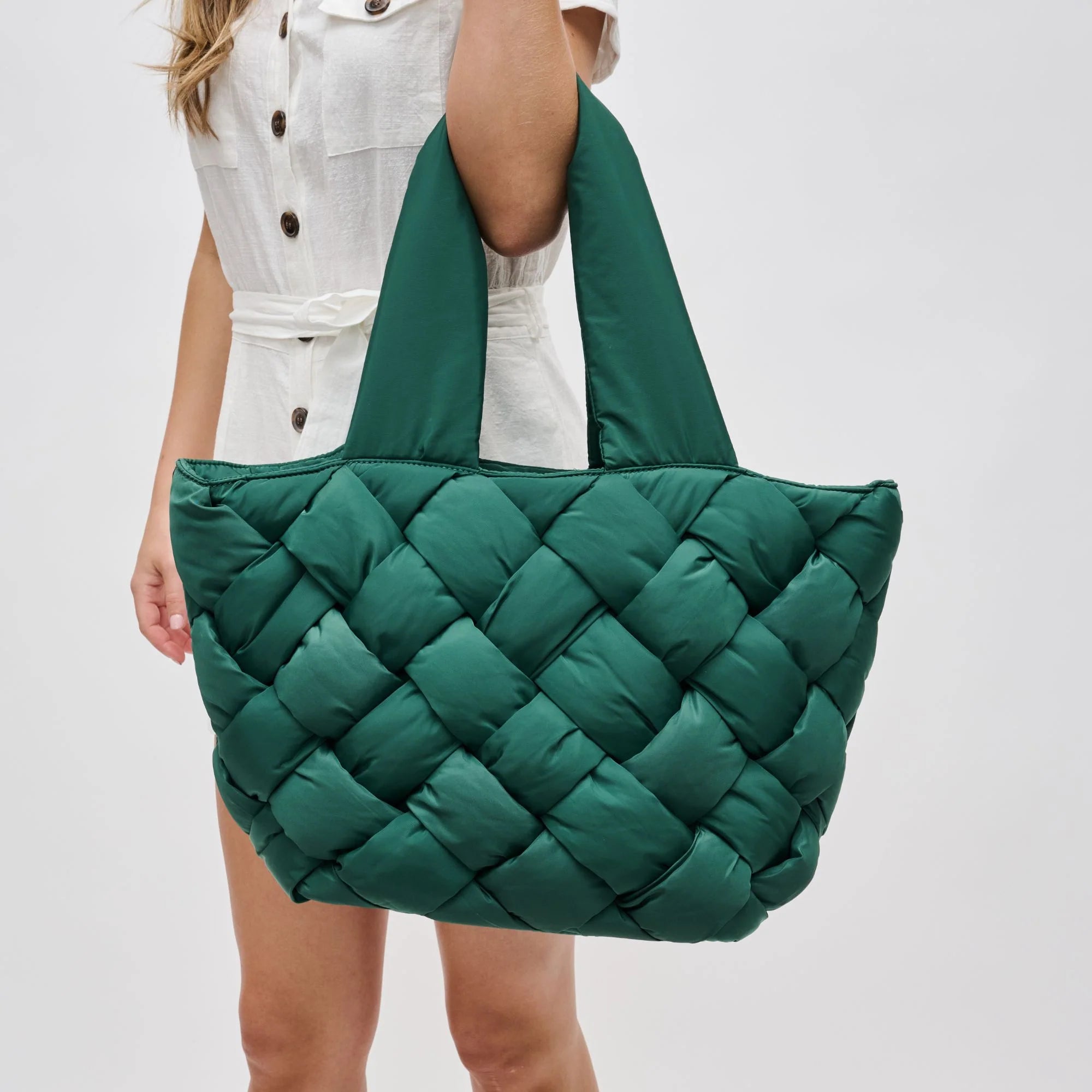 model carrying a green puffy woven tote