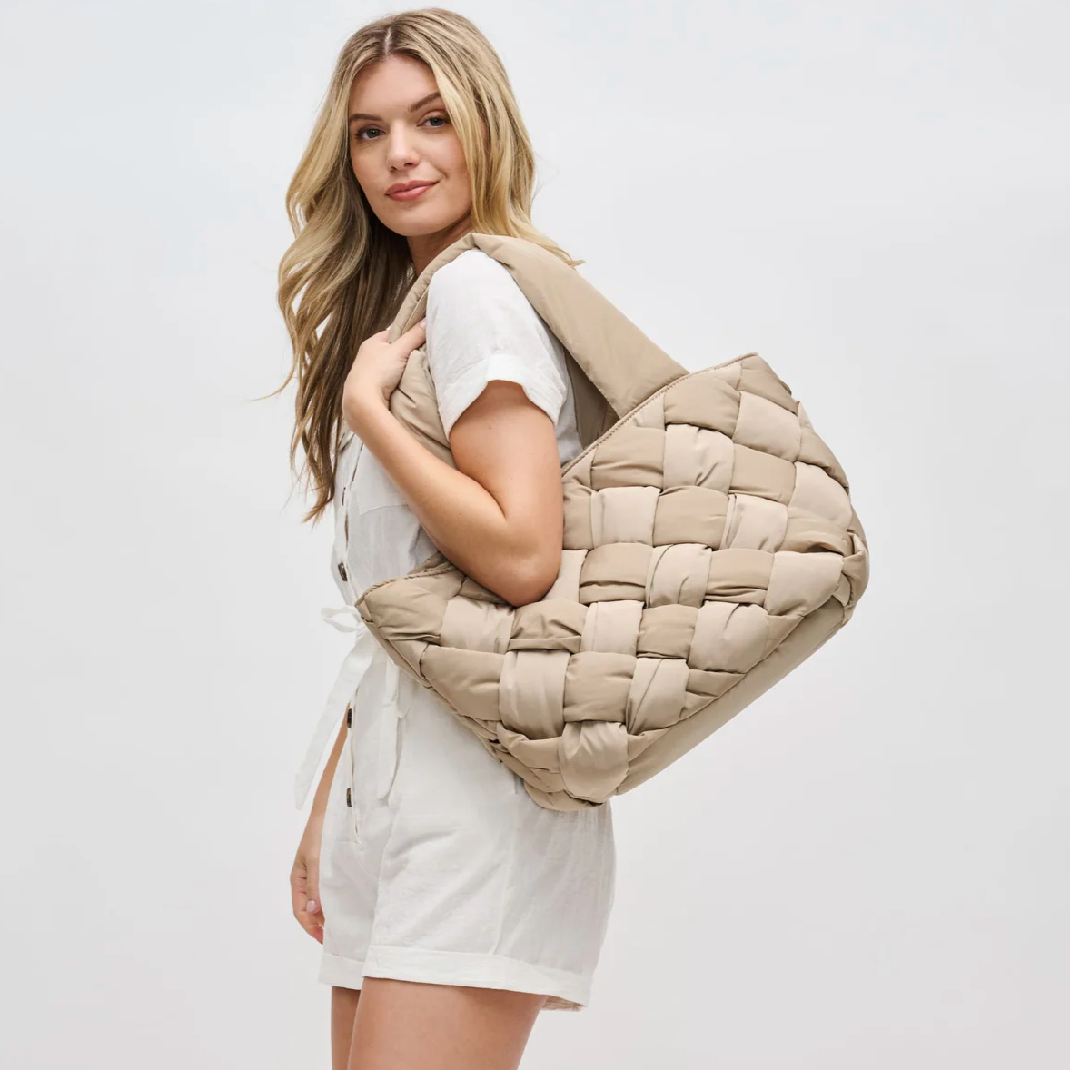 a mom carrying a puffy woven tote bag