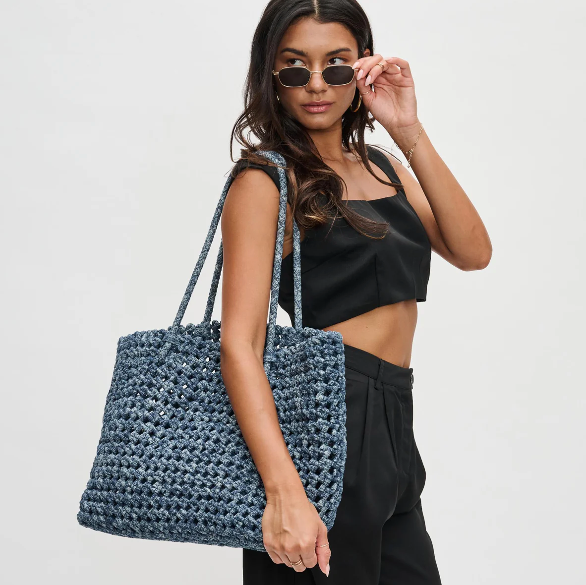 a mom carrying a woven blue tote bag