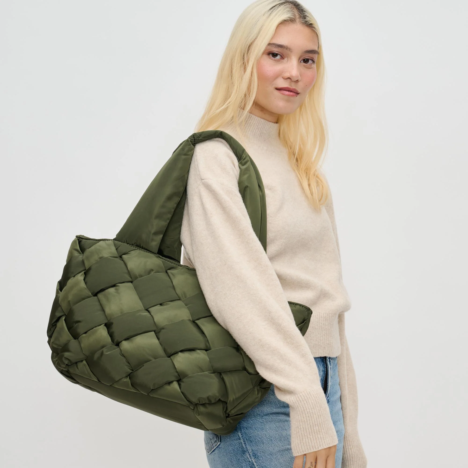 A mom with a green quilted tote on her shoulder