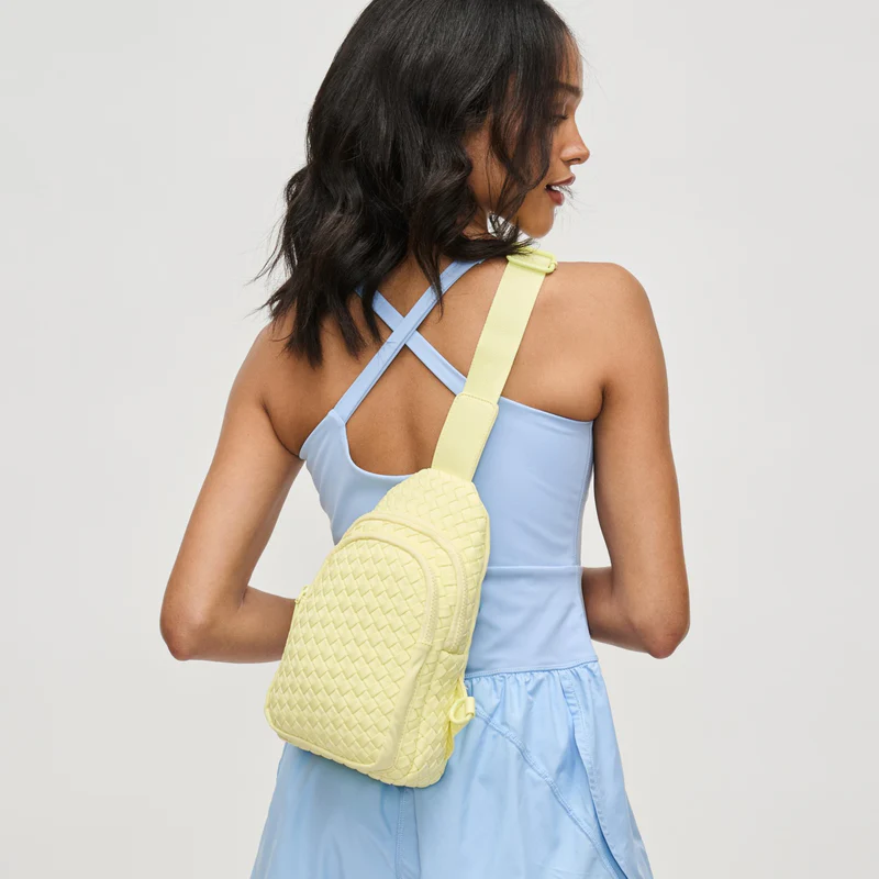 A mom with a yellow sling bag on her back