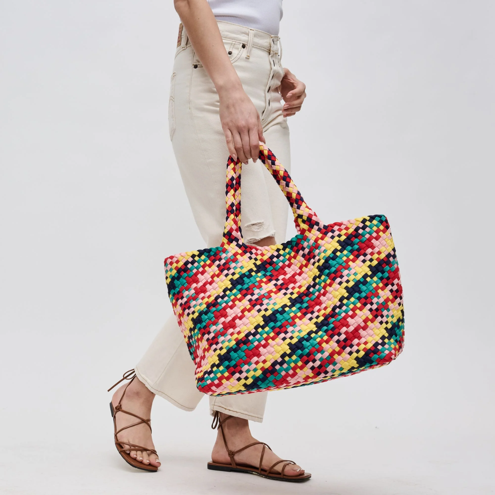 woman carrying a multicolor, lightweight beach tote