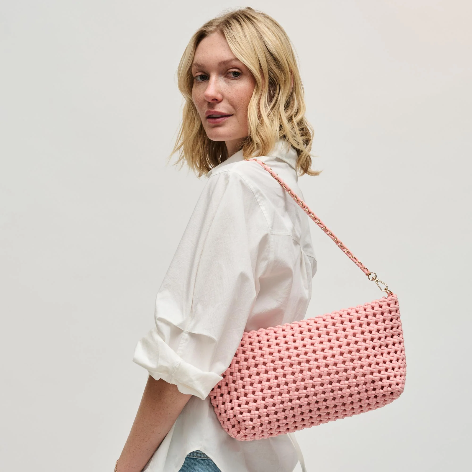Woman carrying a pink braided shoulder bag