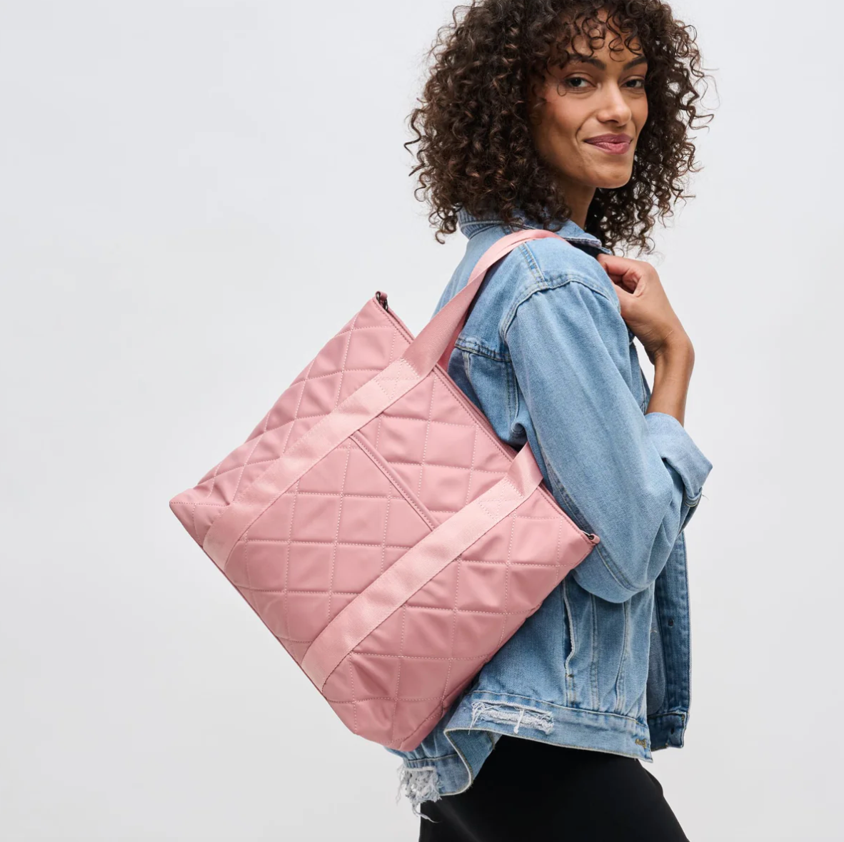 model carrying a pink carryall tote
