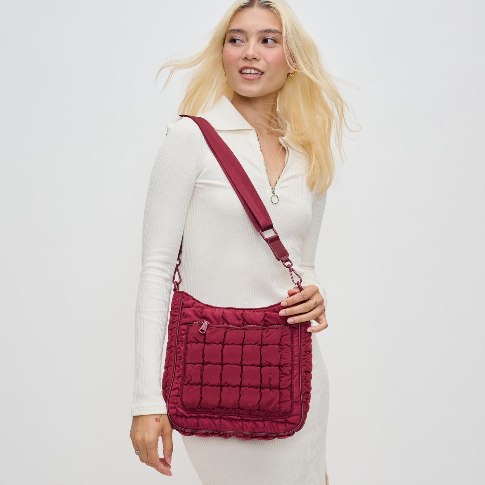woman wearing a red quilted crossbody bag