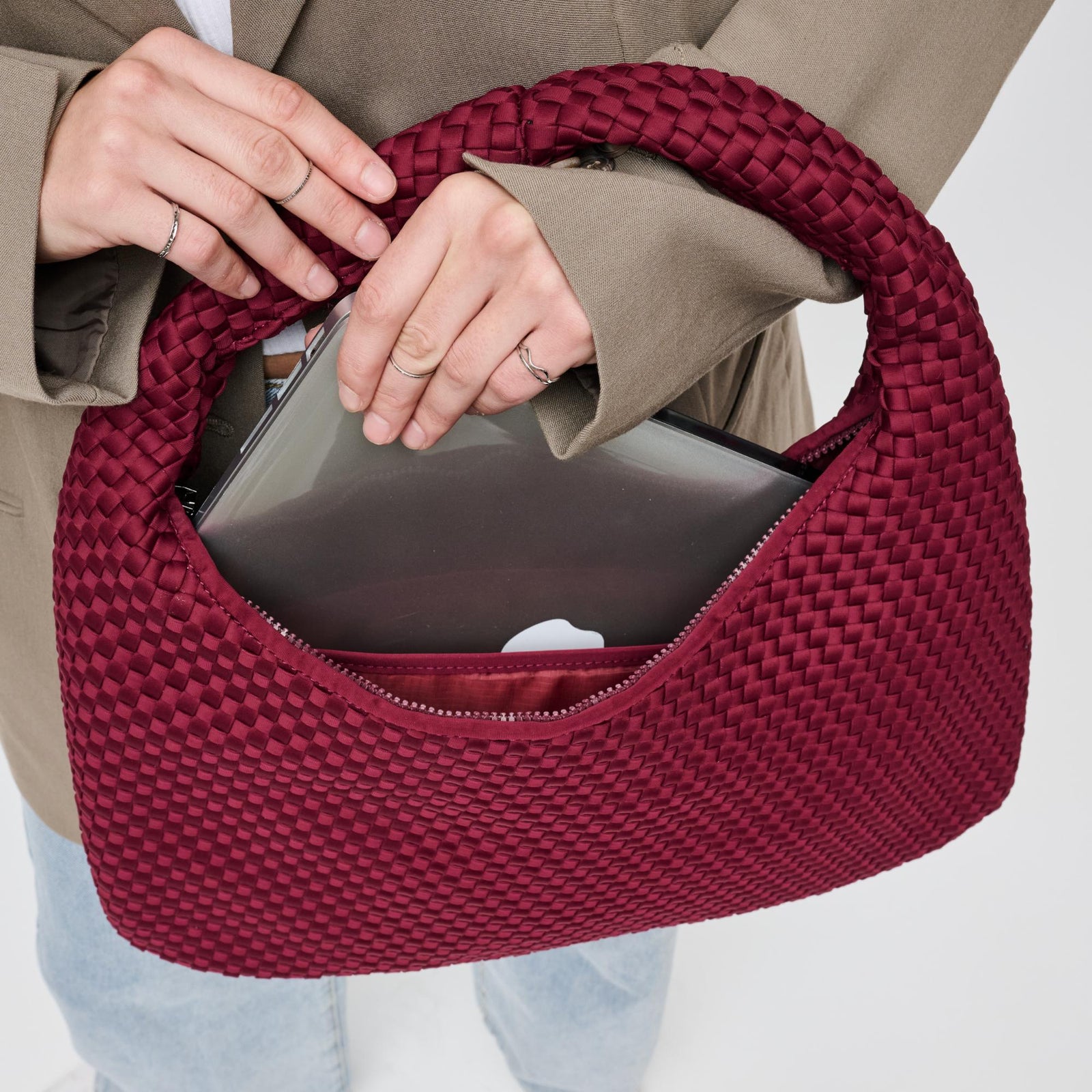 A red woven hobo bag with a laptop
