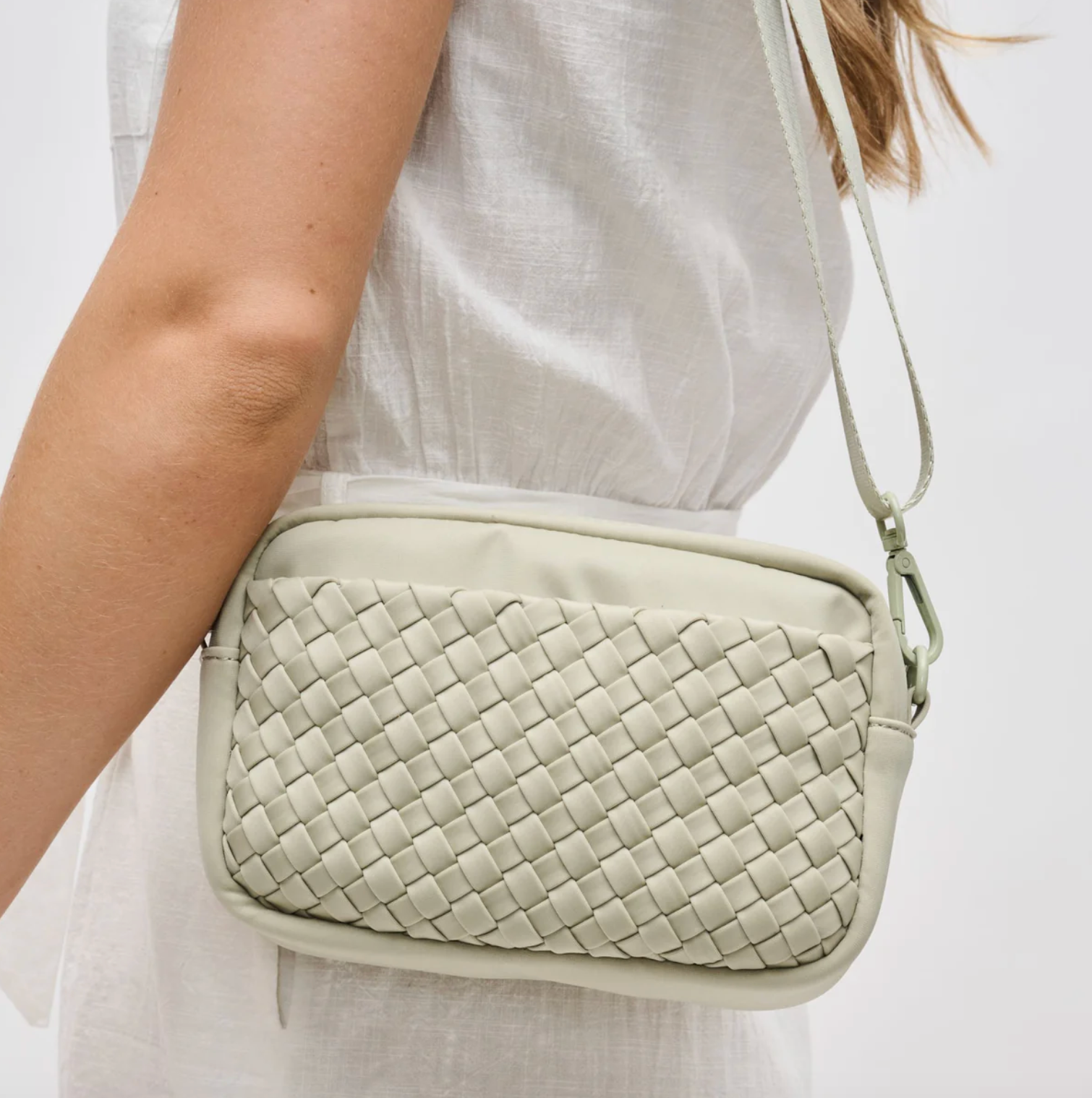 woman wearing a sage crossbody bag