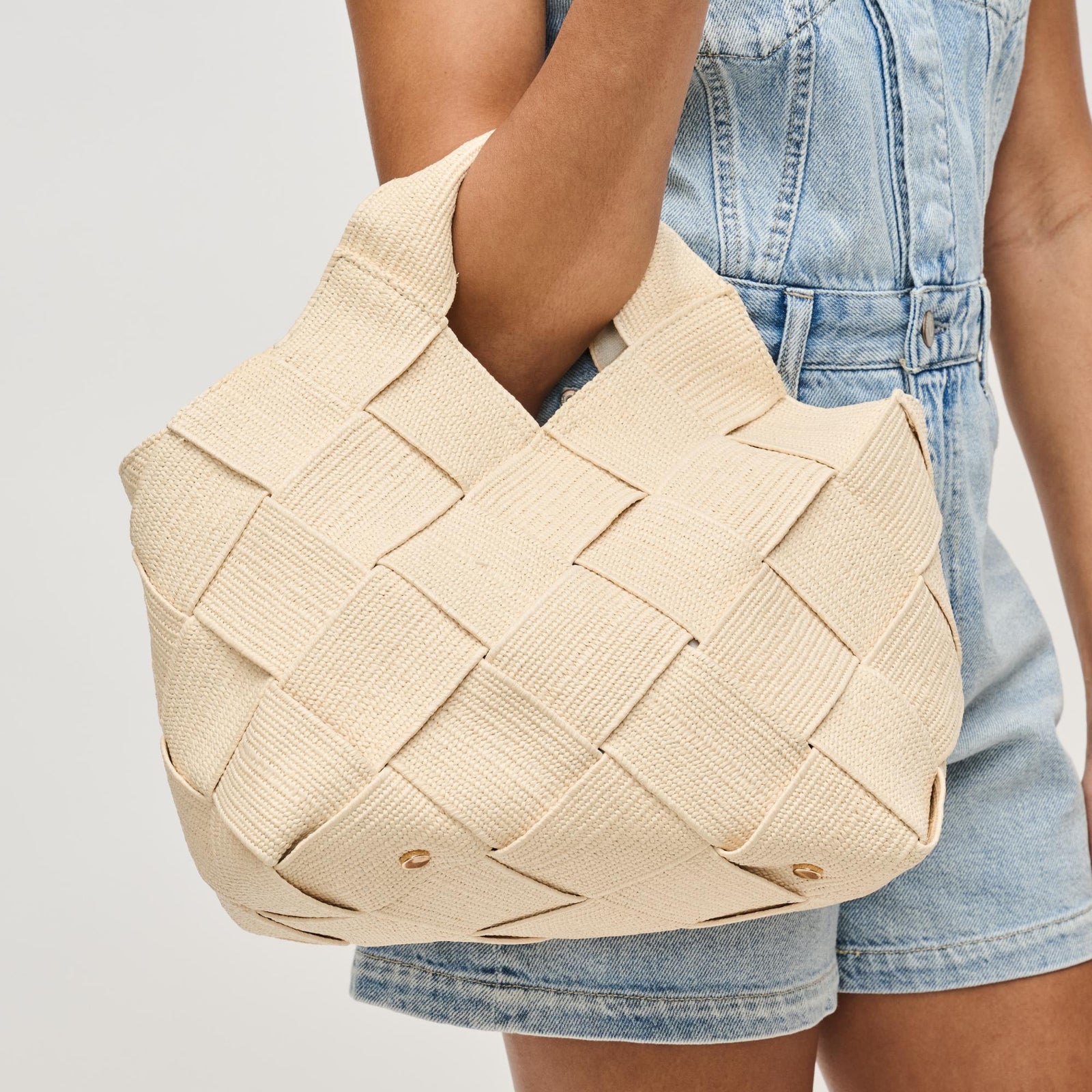 woman holding a sustainable cream handbag