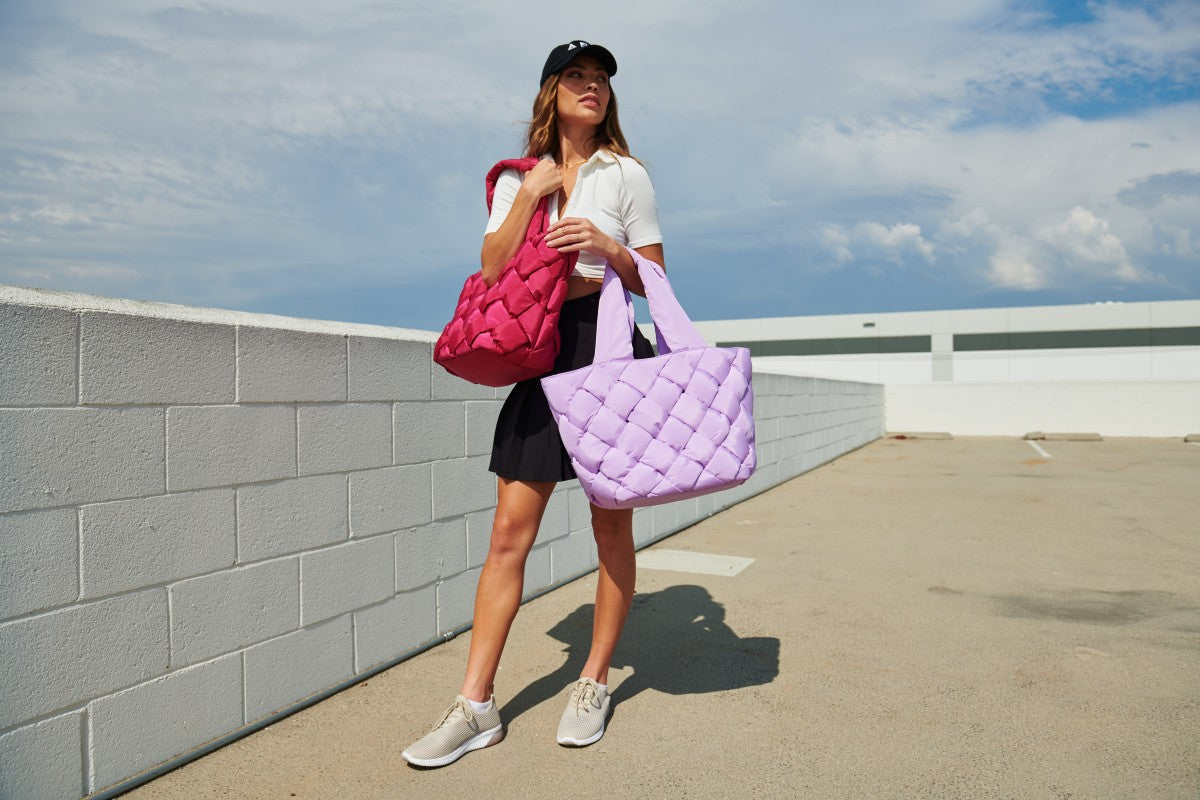 a model carrying two Sol and Selene tote bags