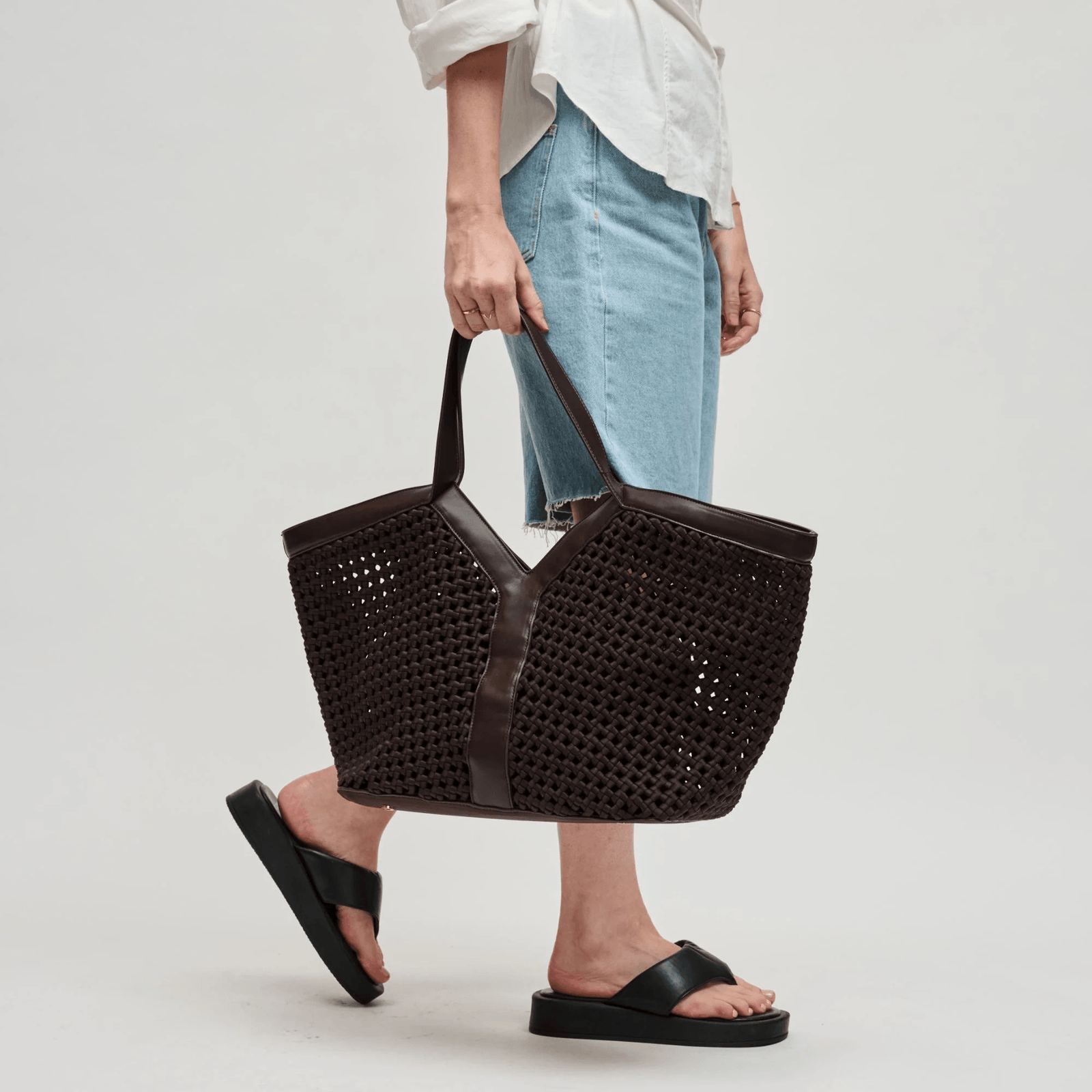 Woman carrying a versatile brown tote bag