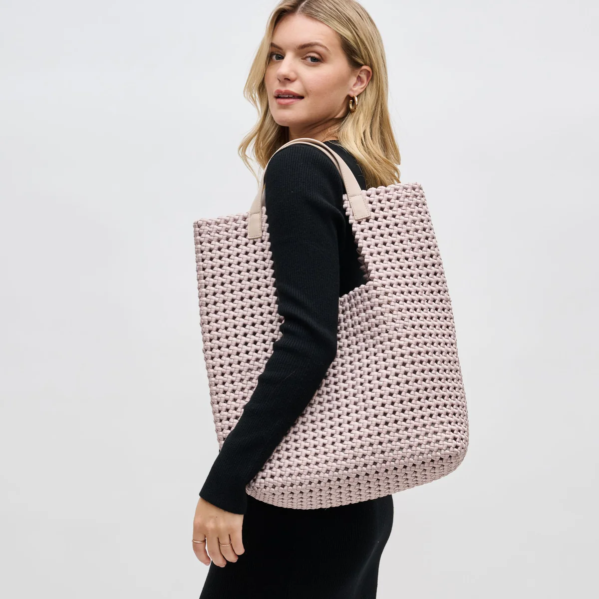 Woman carrying a large woven beach tote