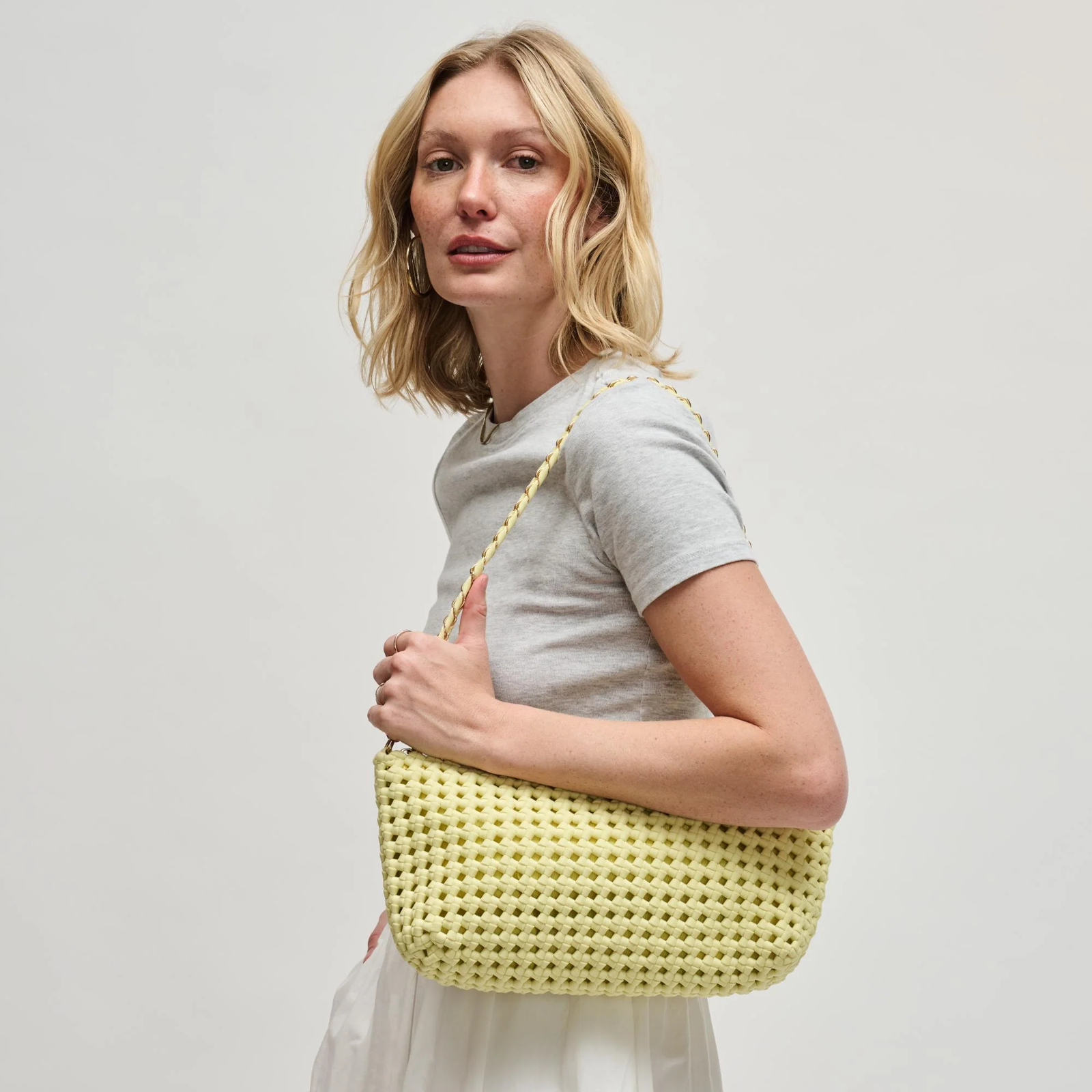 Woman carrying a yellow woven shoulder bag