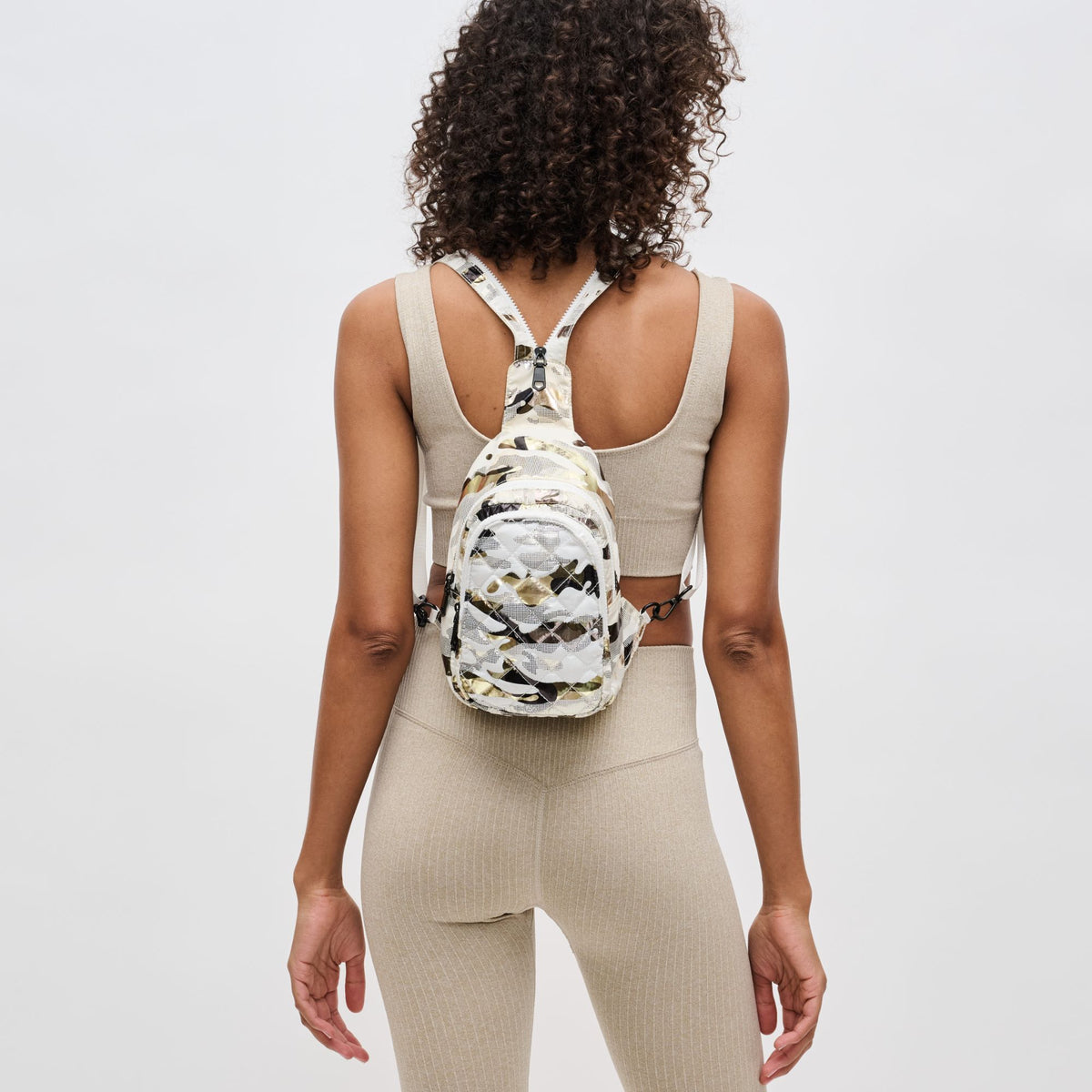 Woman wearing White Metallic Camo Sol and Selene On The Run Sling Backpack 841764106290 View 2 | White Metallic Camo